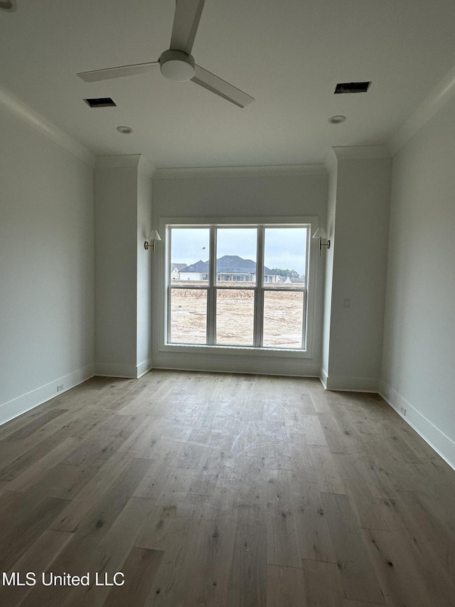 spare room with ceiling fan, ornamental molding, a mountain view, and wood-type flooring