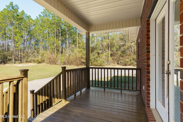 wooden deck with covered porch and a yard