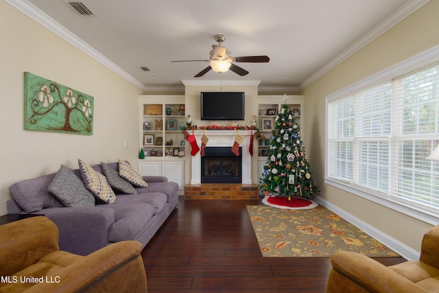 living room featuring ceiling fan, dark hardwood / wood-style flooring, crown molding, and a brick fireplace