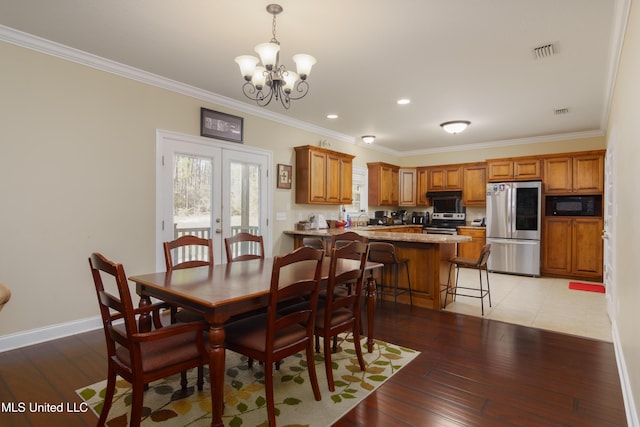 dining space featuring ornamental molding, light hardwood / wood-style flooring, and a notable chandelier