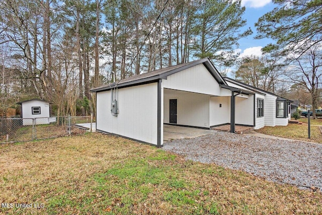 view of side of property featuring a lawn and a carport