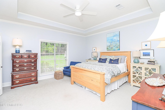 carpeted bedroom featuring a raised ceiling, crown molding, and a ceiling fan