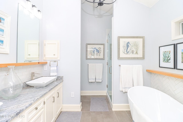 bathroom featuring backsplash, a stall shower, a freestanding bath, and baseboards