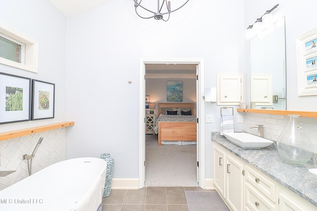 bathroom with a high ceiling, ensuite bath, tile patterned flooring, a freestanding tub, and baseboards