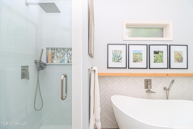 full bathroom with a shower stall, a soaking tub, and tile walls