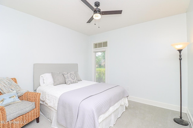 bedroom with light carpet, baseboards, and a ceiling fan
