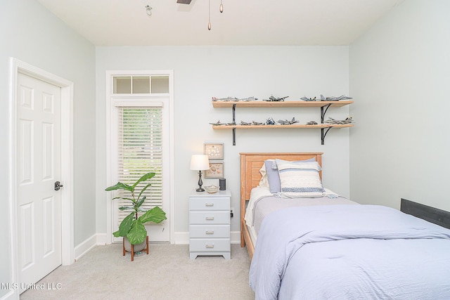 bedroom featuring light carpet and baseboards