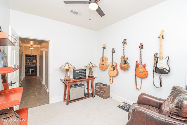 sitting room featuring a ceiling fan and baseboards