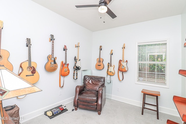 sitting room featuring a ceiling fan, carpet, and baseboards