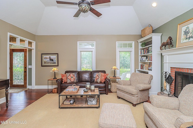 living room with vaulted ceiling, ceiling fan, wood finished floors, baseboards, and a fireplace