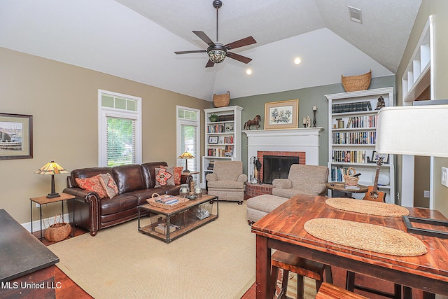 living room with lofted ceiling, wood finished floors, ceiling fan, a brick fireplace, and recessed lighting