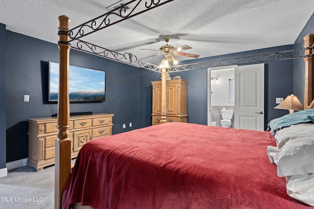 bedroom with baseboards, light colored carpet, a textured ceiling, a ceiling fan, and ensuite bath