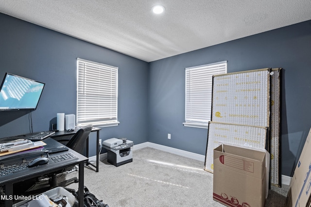 carpeted home office featuring baseboards and a textured ceiling
