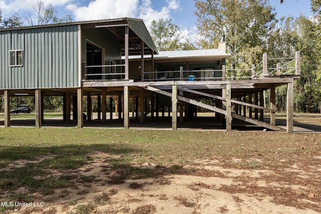 rear view of property featuring a chimney and metal roof