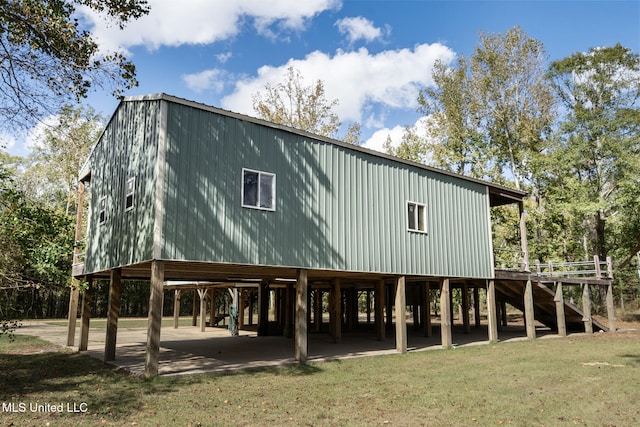 back of house with stairs and a yard