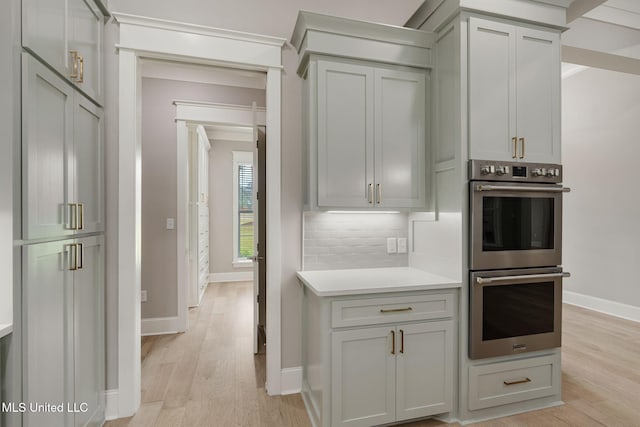 9 Sanctuary Ln, Sumrall, MS 39482 - kitchen with stainless steel double oven, light wood finished floors, light countertops, baseboards, and backsplash