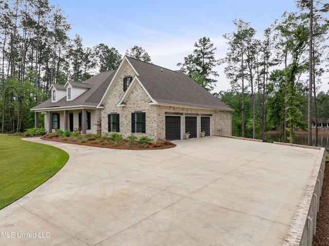 9 Sanctuary Ln, Sumrall, MS 39482 - view of front facade featuring roof with shingles, an attached garage, driveway, and brick siding