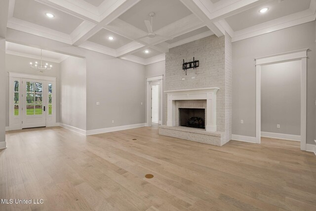 9 Sanctuary Ln, Sumrall, MS 39482 - unfurnished living room featuring baseboards, coffered ceiling, ceiling fan with notable chandelier, and light wood-type flooring