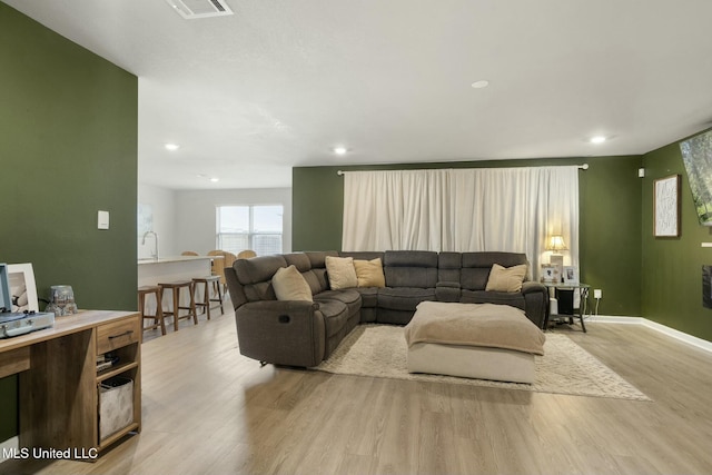 living room with sink and light hardwood / wood-style flooring