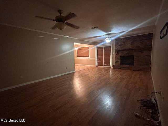 unfurnished living room with crown molding, a fireplace, wood-type flooring, and ceiling fan