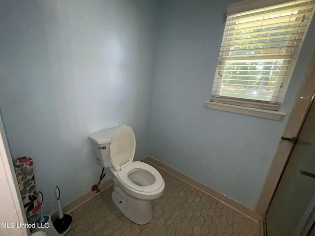 bathroom featuring toilet and tile patterned flooring