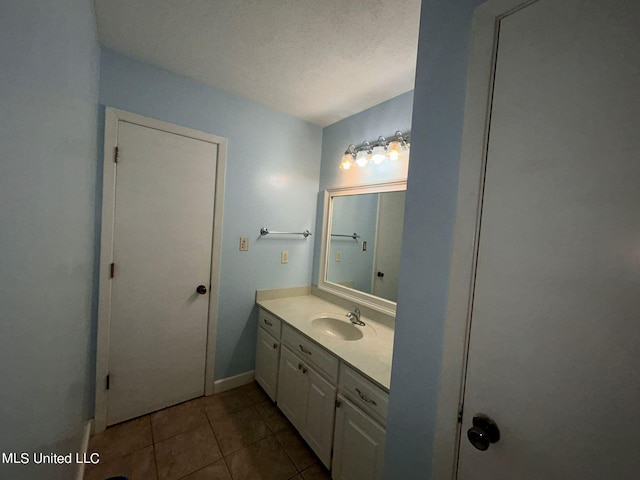 bathroom featuring vanity, a textured ceiling, and tile patterned flooring