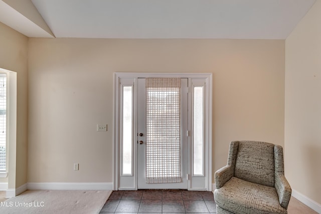 entrance foyer featuring lofted ceiling, plenty of natural light, and tile patterned flooring