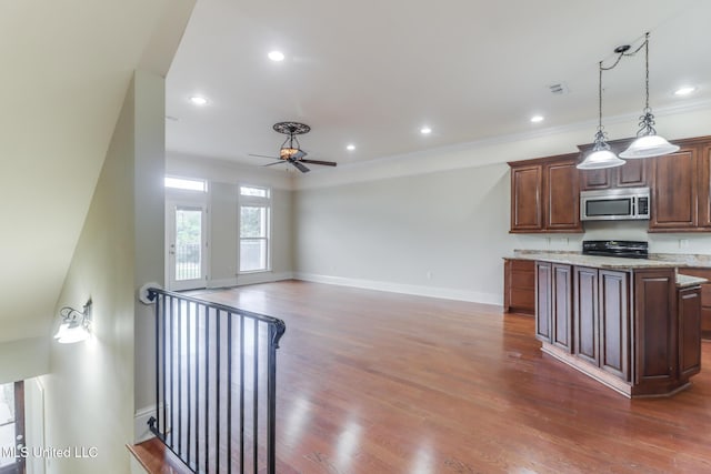 25 Oak Alley Ln Unit 25, Long Beach, MS 39560 - kitchen featuring stainless steel microwave, ceiling fan, dark wood-style flooring, a center island, and decorative light fixtures
