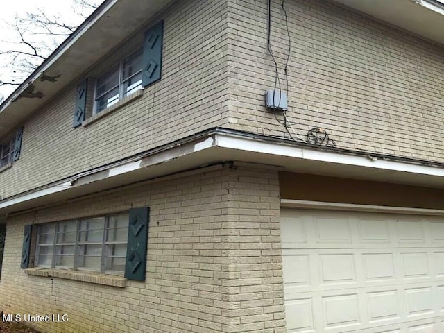 view of home's exterior with a garage and brick siding