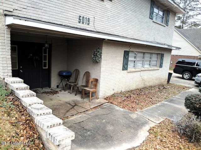 exterior space featuring a patio area and brick siding