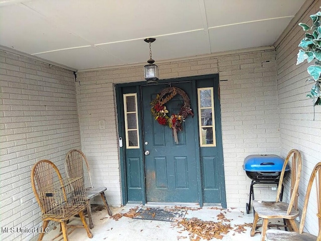 view of exterior entry with brick siding