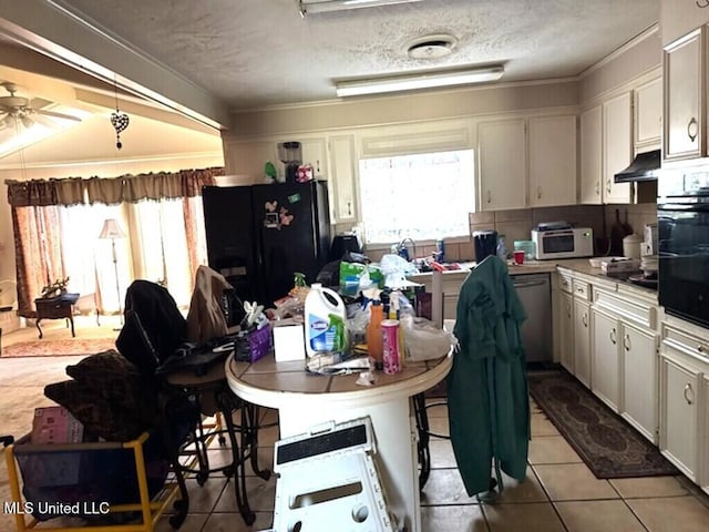 kitchen with a healthy amount of sunlight, white cabinetry, under cabinet range hood, and black appliances