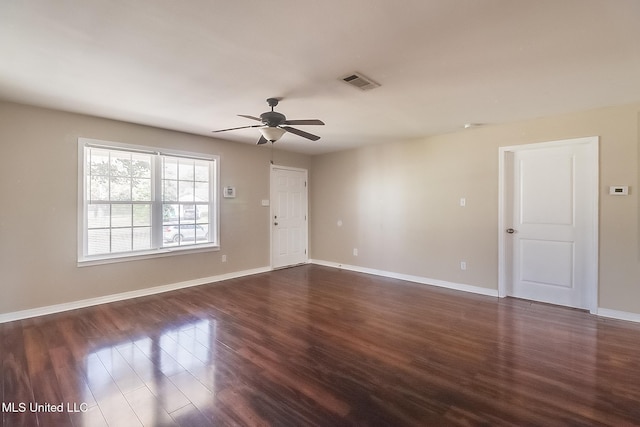 empty room with ceiling fan and dark wood-type flooring