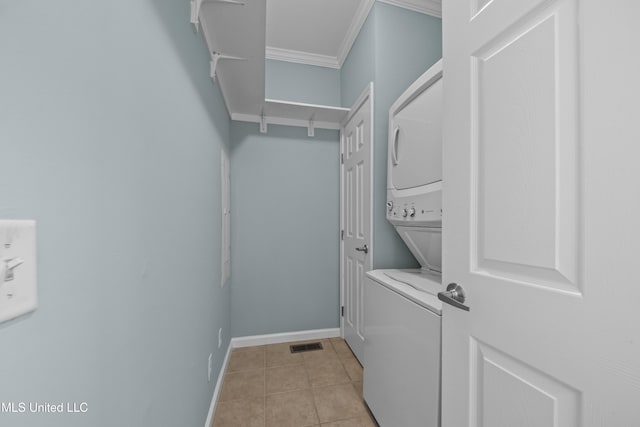 1515 E Beach Blvd Unit 114, Pass Christian, MS 39571 - washroom featuring stacked washer / dryer, crown molding, light tile patterned flooring, and baseboards