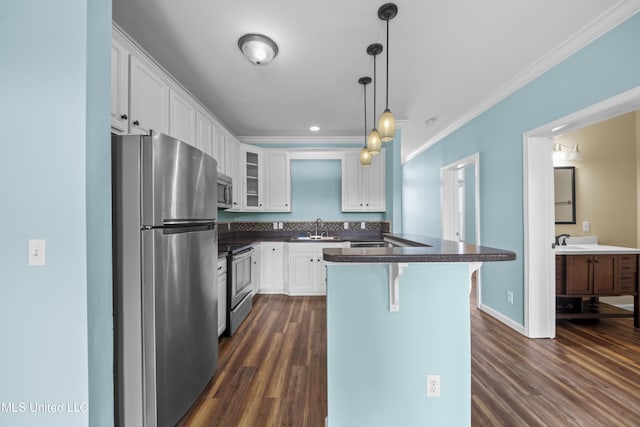 1515 E Beach Blvd Unit 114, Pass Christian, MS 39571 - kitchen featuring stainless steel appliances, a sink, dark countertops, white cabinetry, and dark wood-style floors
