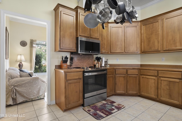 311 Pinecrest Blvd, Long Beach, MS 39560 - kitchen with appliances with stainless steel finishes, light tile patterned floors, brown cabinetry, ornamental molding, and a chandelier