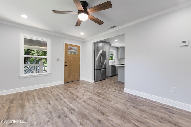 unfurnished living room with ceiling fan, crown molding, and light hardwood / wood-style flooring