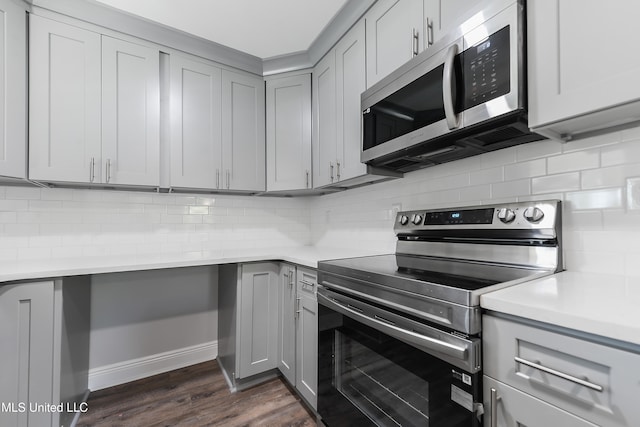 kitchen featuring tasteful backsplash, stainless steel appliances, and dark hardwood / wood-style floors