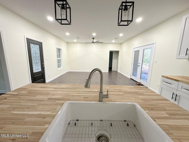 kitchen with pendant lighting, hardwood / wood-style floors, and white cabinets