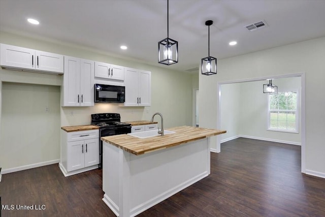 kitchen featuring white cabinetry, black appliances, decorative light fixtures, an island with sink, and wood counters