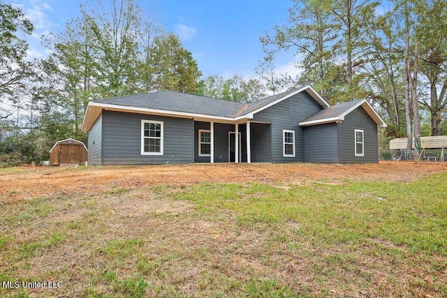 view of front of house featuring a front lawn and a shed