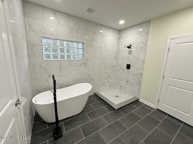 bathroom with tile walls, tile patterned floors, and independent shower and bath