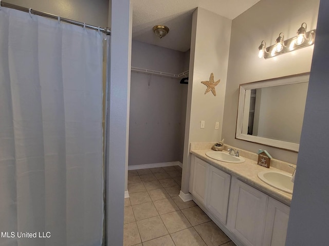 bathroom featuring tile patterned floors, a textured ceiling, and vanity