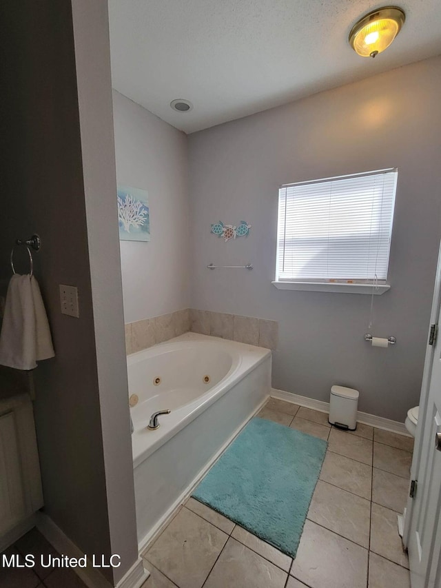 bathroom featuring a bathtub, tile patterned floors, and toilet