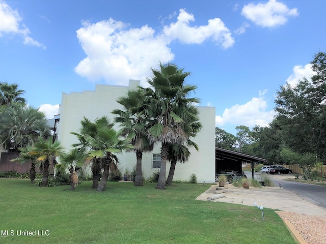 2501 Gulf Ave Unit 22, Gulfport, MS 39501 - view of property exterior featuring a lawn, an attached carport, and concrete driveway