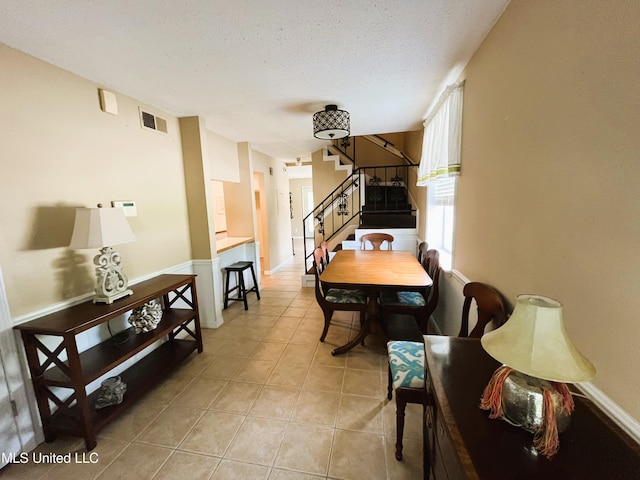 2501 Gulf Ave Unit 22, Gulfport, MS 39501 - dining area featuring stairway, light tile patterned floors, baseboards, and a textured ceiling