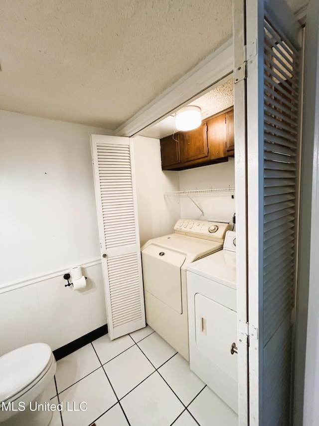 2501 Gulf Ave Unit 22, Gulfport, MS 39501 - washroom featuring separate washer and dryer, light tile patterned flooring, and a textured ceiling