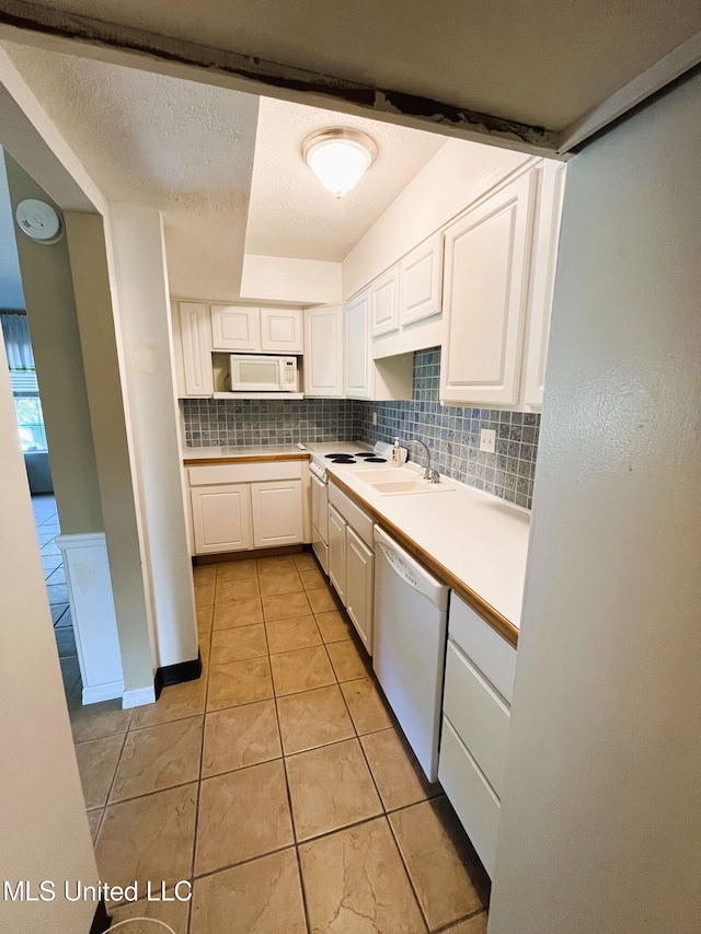 2501 Gulf Ave Unit 22, Gulfport, MS 39501 - kitchen featuring white appliances, white cabinets, light tile patterned floors, light countertops, and tasteful backsplash