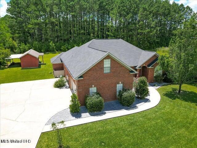 19101 Rucks Krans Rd, Moss Point, MS 39562 - view of side of property with concrete driveway, a yard, brick siding, and an attached garage