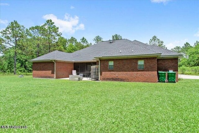 19101 Rucks Krans Rd, Moss Point, MS 39562 - rear view of property with a sunroom, a yard, brick siding, and roof with shingles